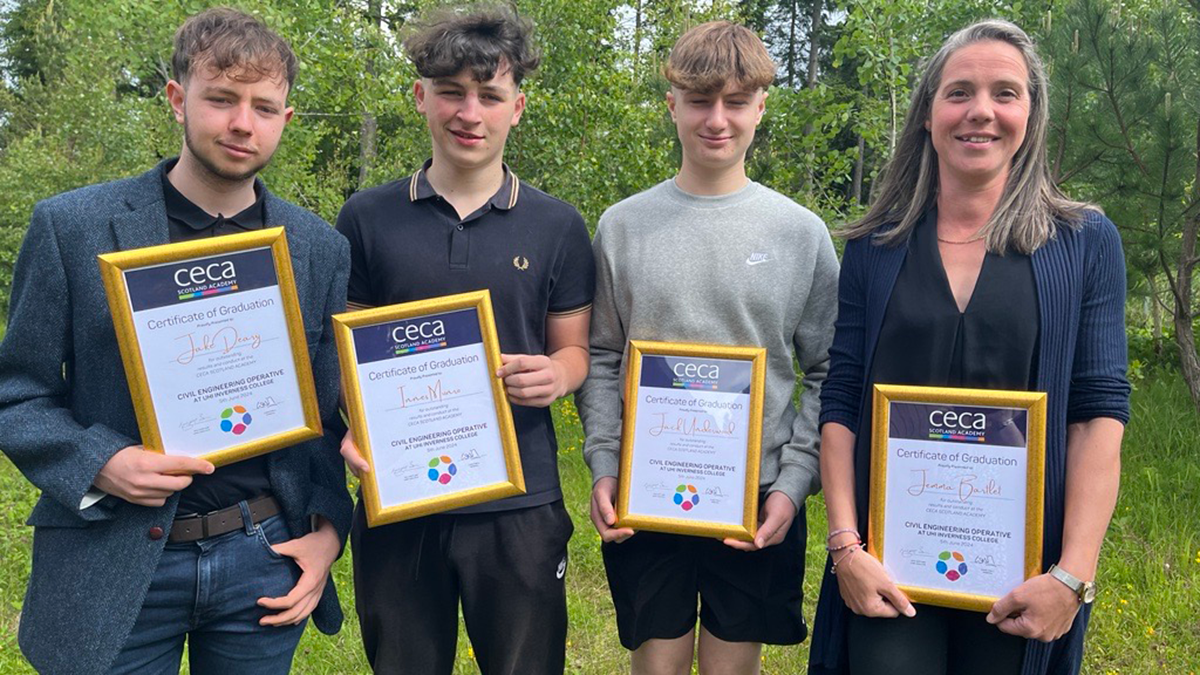 four graduates holding up their certificates