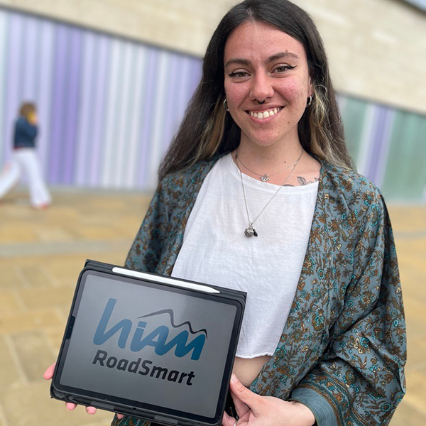 Female student Llara Plaza holding her blue and white logo design