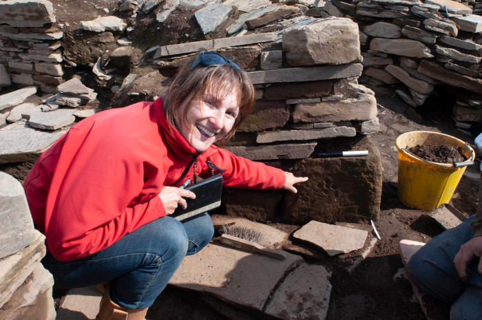 Antonia Thomas looking at rock art at the Ness of Brodgar