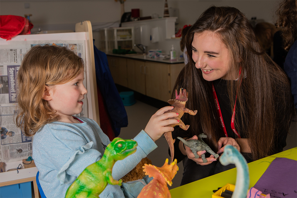 Person talking to a child about a dinosaur