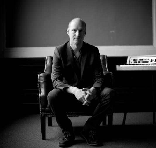 Man sitting next to keyboard in black and white