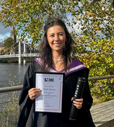 Niamh Murray holding her certificate and scroll in her graduation gown