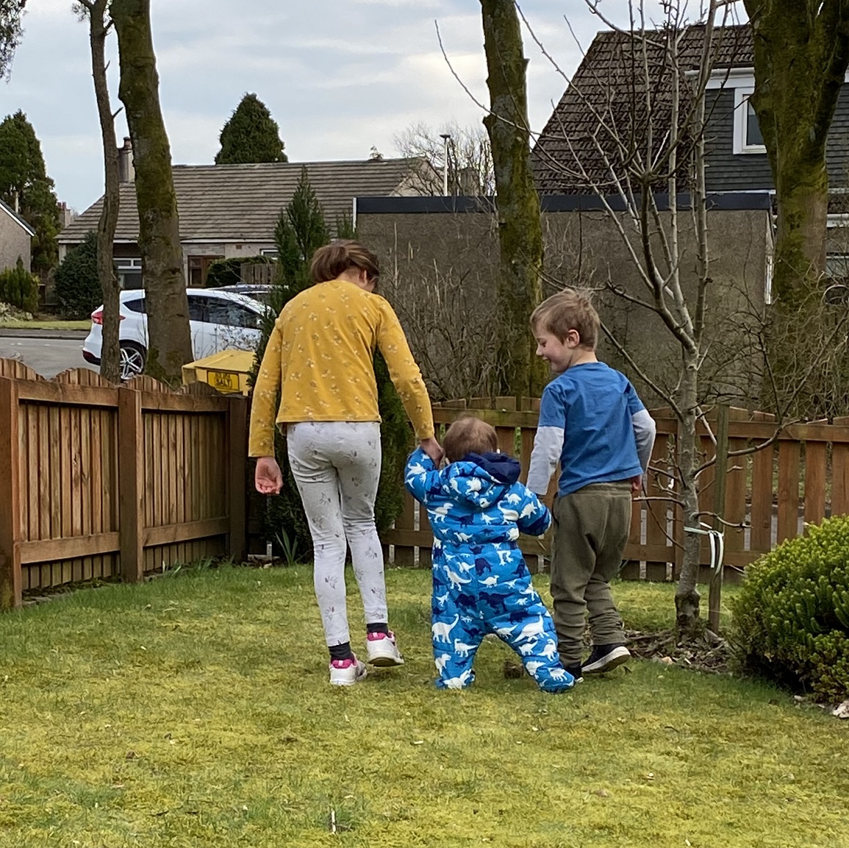 Three young children in a surburban garden