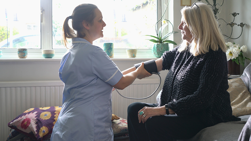 A nurse taking a persons blood pressure