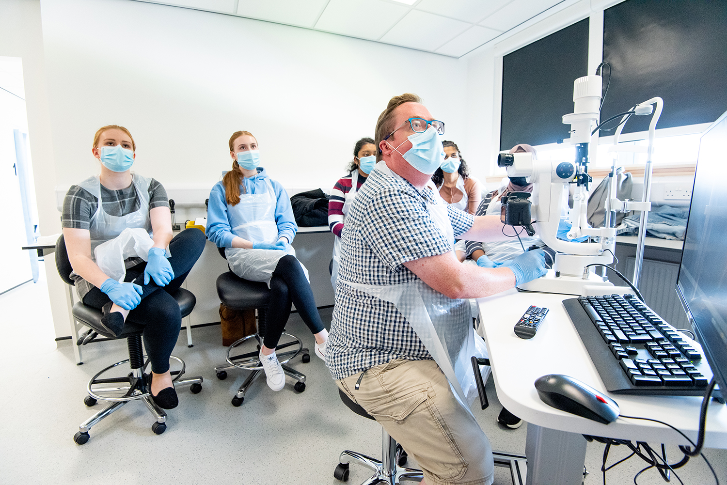 Optometry students sitting in a circle looking at a screen