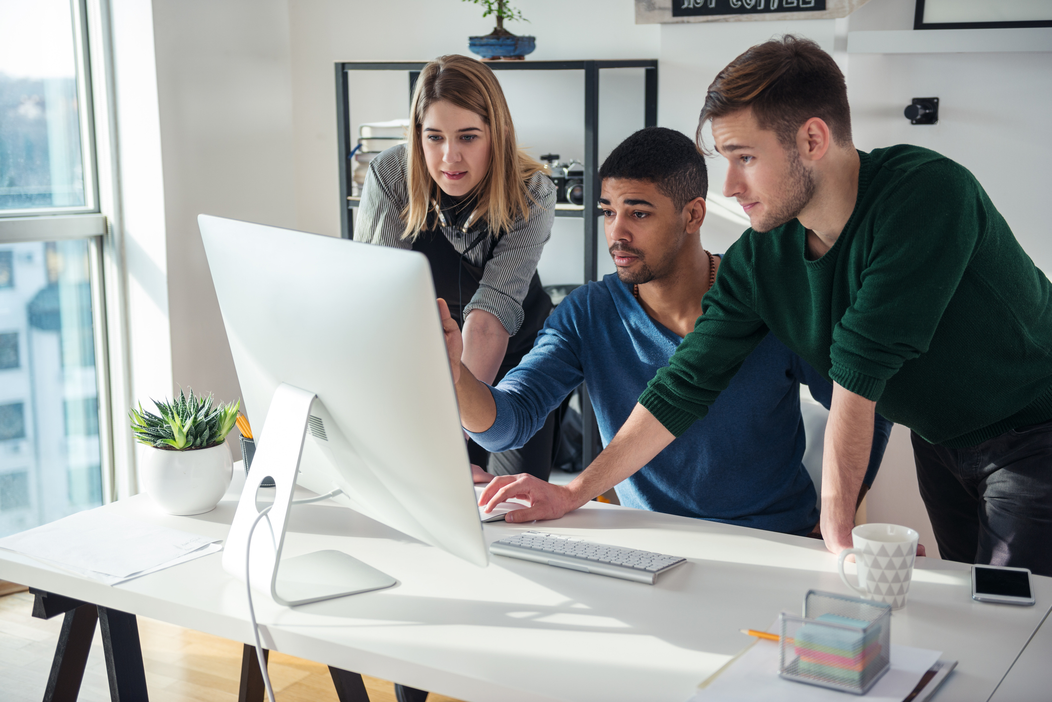 Three people looking at computer screen