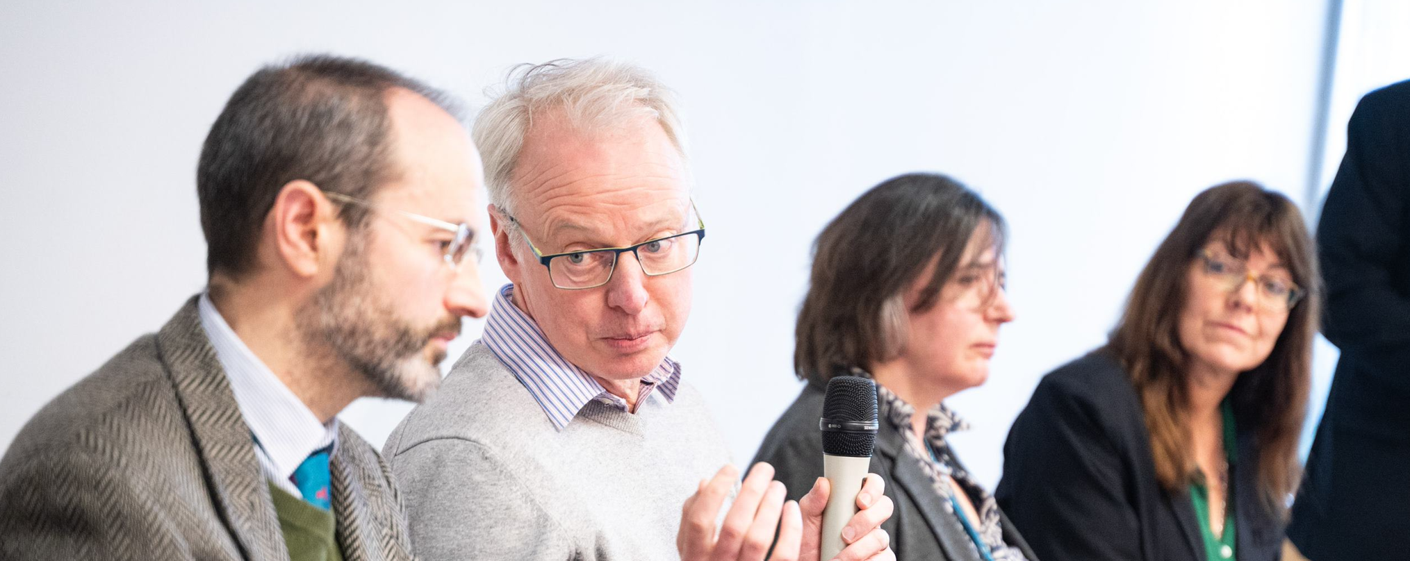 Four panel members at a conference