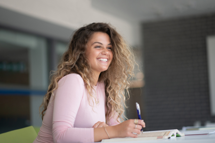 A student smiling at a laptop